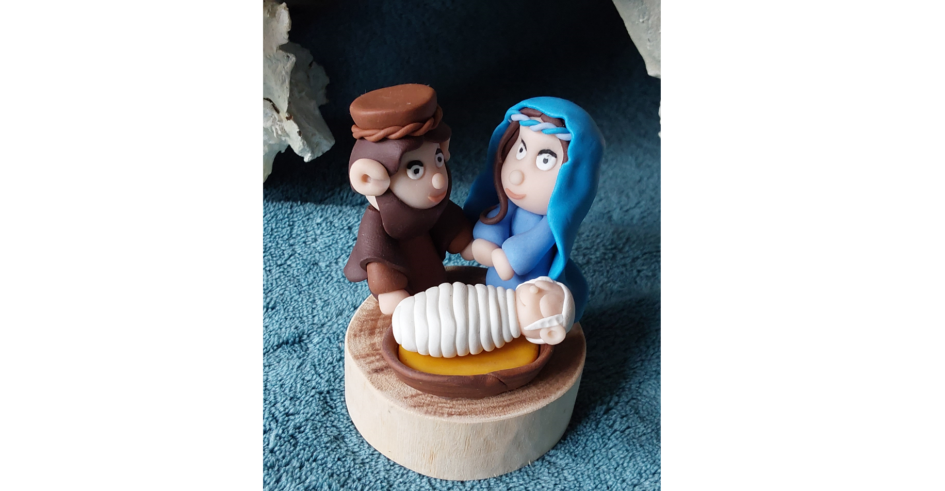 Une crèche minimaliste, puisqu'elle ne comprend que Joseph, Marie et l'enfant Jésus dans sa mangeoire, le tout sur un socle de bois de palme.